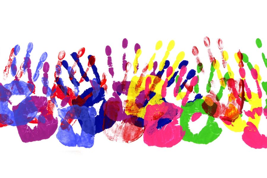Horizontal border pattern of child handprints made from vivid acrylic paint isolated on a white paper background.